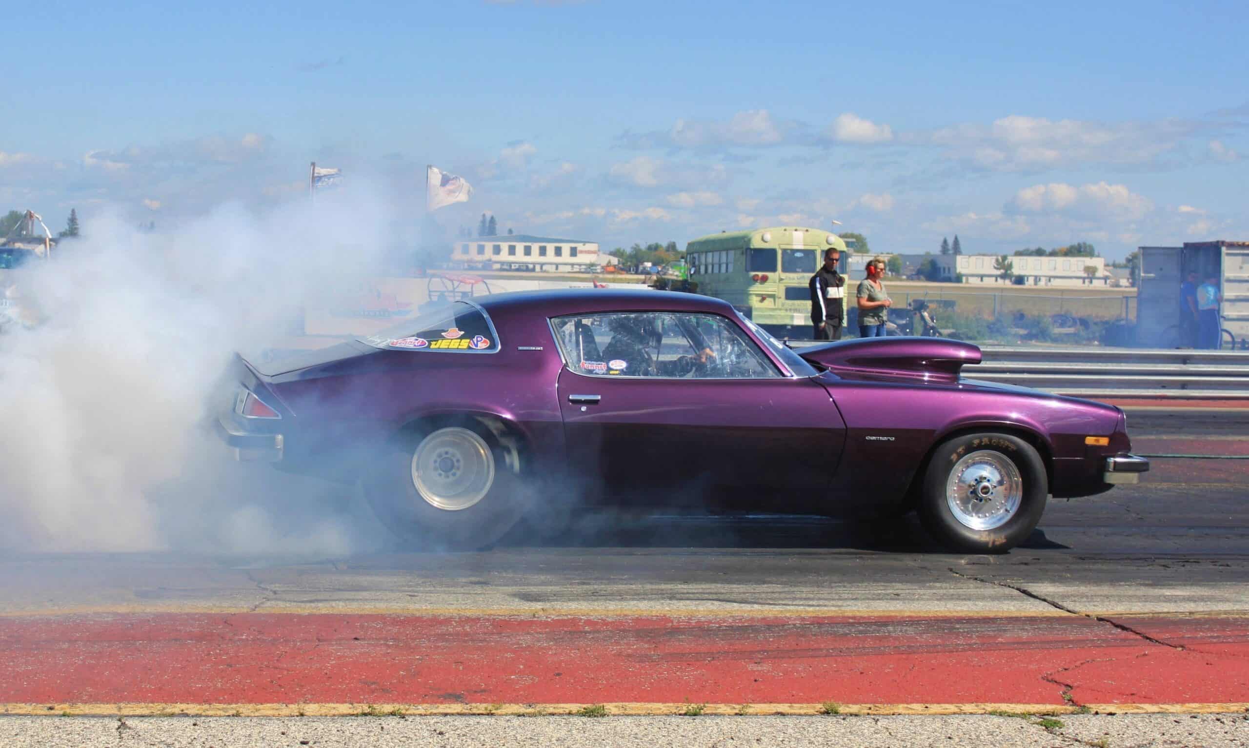 a muscle car revving up with smoke coming from the wheels